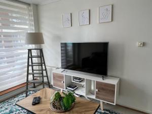 a living room with a flat screen tv on a wall at Departamento amoblado en Parque Urbano in Concepción