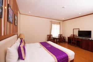 una camera d'albergo con letto e TV di Khách sạn Phú Mỹ a HÆ°ng YÃªn