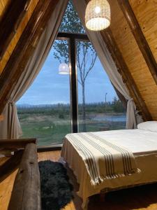 a bedroom with a bed and a large window at Finca Las Liebres in San Rafael