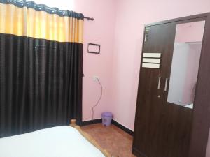 a bedroom with a black curtain and a mirror at smile stone individual cottage in Ooty