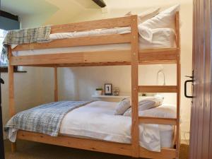 a bedroom with two bunk beds with white sheets at Ivory Cottage in Woolacombe