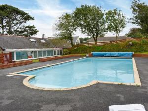 a swimming pool in front of a house at Ivory Cottage in Woolacombe