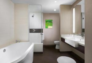 uma casa de banho com 2 lavatórios, uma banheira e um WC. em Gorgeous Suite Vdara 22nd FLR - POOL View - FREE Valet em Las Vegas