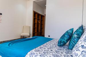 1 dormitorio con cama azul y almohadas azules en Villa luxurieuse neuve Jasmin, en Marrakech