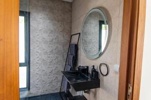 baño con lavabo negro y espejo en Villa luxurieuse neuve Jasmin, en Marrakech