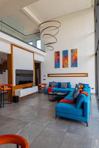 sala de estar con sofás azules y TV de pantalla plana en Villa luxurieuse neuve Jasmin, en Marrakech