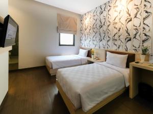 Hotel 88 Mangga Besar 62 Lokasari By WH في جاكرتا: غرفة فندقية بسريرين وتلفزيون