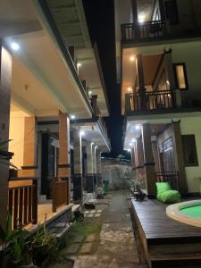 a hallway of a building with a swimming pool at night at Bima Homestay Lembongan in Nusa Lembongan