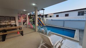 a house with a swimming pool with chairs and a table at Family POOL VILLA CHAAM in Cha Am