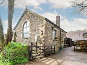 an old stone church with a fence in front of it at Chapel Cottage in Lydford