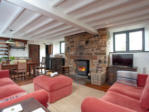 a living room with red furniture and a fireplace at Chapel Cottage in Lydford