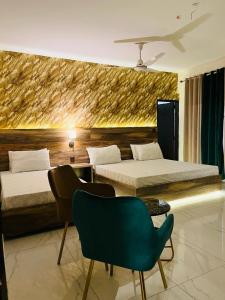 una habitación de hotel con 2 camas y una silla verde en TULIP HOTELS AND APPARTMENTS en Karachi