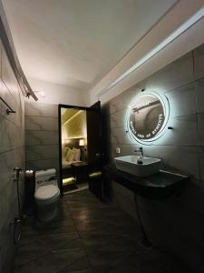W łazience znajduje się toaleta, umywalka i lustro. w obiekcie TULIP HOTELS AND APPARTMENTS w mieście Karaczi