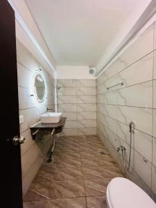 W łazience znajduje się umywalka, toaleta i lustro. w obiekcie TULIP HOTELS AND APPARTMENTS w mieście Karaczi
