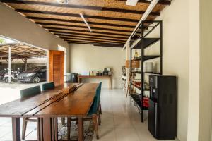 a dining room with a table and a refrigerator at Outpost Ubud Bungalows in Ubud