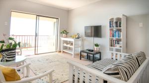uma sala de estar com um sofá e uma televisão em A-View-at-Kingfisher Port Alfred Guest Accommodation em Port Alfred