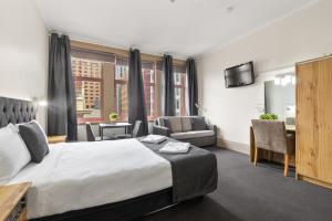 um quarto de hotel com uma cama grande e uma secretária em Adelaide Paringa em Adelaide