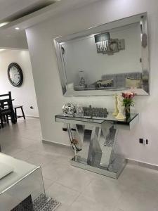 a room with a mirror and a table with flowers at Condo in Santiago De Los Caballeros in Santiago de los Caballeros