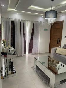 a living room with a couch and a glass table at Condo in Santiago De Los Caballeros in Santiago de los Caballeros