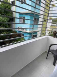 una silla sentada en un balcón junto a una ventana en Condo in Santiago De Los Caballeros, en Santiago de los Caballeros