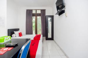 um quarto de hotel com uma cama e uma televisão em RedDoorz Syariah near Grand Galaxy Park em Ceger