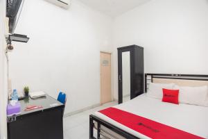 um quarto com uma cama e uma secretária. em RedDoorz Syariah near Grand Galaxy Park em Ceger