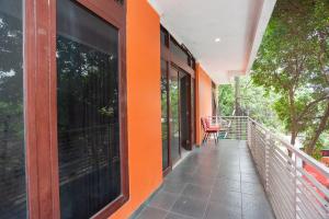 uma casa laranja com uma varanda com uma cadeira em RedDoorz Syariah near Grand Galaxy Park em Ceger