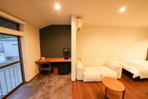 um quarto com um sofá, uma cama e uma secretária em ZENYA - Vacation STAY 89352v em Nakano
