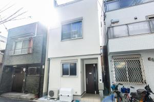 une maison blanche avec des vélos garés devant elle dans l'établissement TY HOUSE 生野, à Osaka