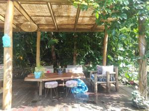 una mesa de madera y sillas bajo una pérgola de madera en Soul Rise en Taravao