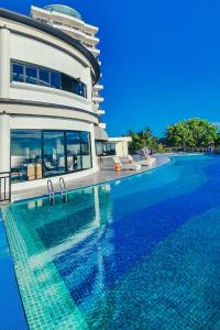 a large swimming pool next to a large building at BW Suite Belitung in Tanjungpandan