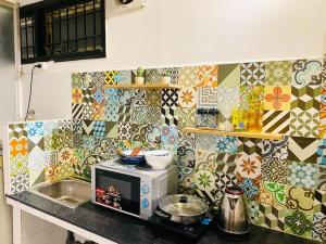 a kitchen with a microwave on a counter with colorful tiles at Studio Lagom 16, độc đáo và yên bình, kế bên dinh độc lập, nhà thờ Đức Bà ,đường Nguyễn du, phường Bến nghé, quận 1 in Ho Chi Minh City