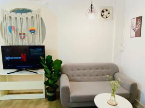 a living room with a couch and a tv at Studio Lagom 16, độc đáo và yên bình, kế bên dinh độc lập, nhà thờ Đức Bà ,đường Nguyễn du, phường Bến nghé, quận 1 in Ho Chi Minh City