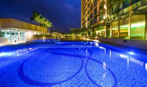 a large swimming pool in front of a building at night at The Light Hotel Penang in Perai