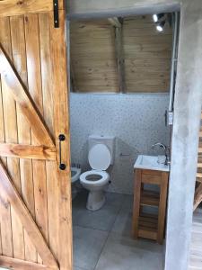 baño con aseo y puerta de madera en Finca Las Liebres en San Rafael