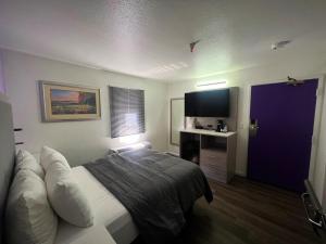 a hotel room with a bed and a flat screen tv at The Aqua Pacific Hotel in Santa Cruz