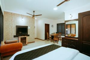 a bedroom with a bed and a television and a table at Asokam Beach Resort in Kannur