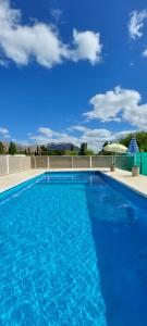 uma grande piscina azul com um céu azul em Casa de campo - Campos del Tacu em Zonda