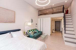 1 dormitorio con cama, escalera y sofá en Ocean Marina Suite View, en Yeosu