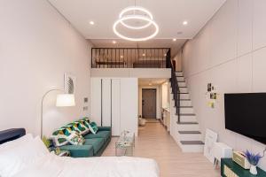 een woonkamer met een bank en een trap bij Ocean Marina Suite View in Yeosu