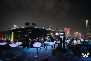 a group of people sitting at tables on a rooftop at night at Studio Lagom 16, độc đáo và yên bình, kế bên dinh độc lập, nhà thờ Đức Bà ,đường Nguyễn du, phường Bến nghé, quận 1 in Ho Chi Minh City