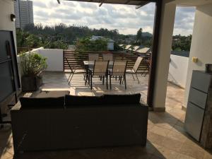eine Terrasse mit einem Tisch und Stühlen auf dem Balkon in der Unterkunft VIP Chain Resort in Rayong