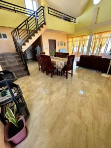 una sala da pranzo con tavolo, sedie e scala di New road private home a Roxas City