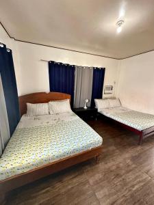 2 letti in una camera con tende blu di New road private home a Roxas City