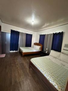 una camera con due letti e tende blu di New road private home a Roxas City