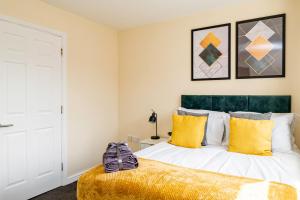グレート・バーにあるFree Parking Spacious House Near Birminghamの黄色い枕が置かれたベッドのある寝室