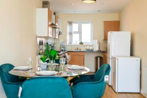 a kitchen with a table and chairs and a refrigerator at Free Parking Spacious House Near Birmingham in Great Barr