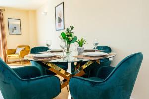 a dining room with a table and blue chairs at Free Parking Spacious House Near Birmingham in Great Barr