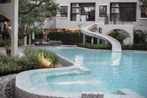 a swimming pool with a slide in front of a building at Lacasita Near Beach Huahin (Room652) in Hua Hin