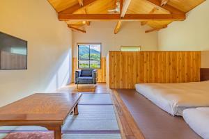 een slaapkamer met een bed, een tafel en een stoel bij Sengokuhara Shinanoki Ichinoyu in Hakone